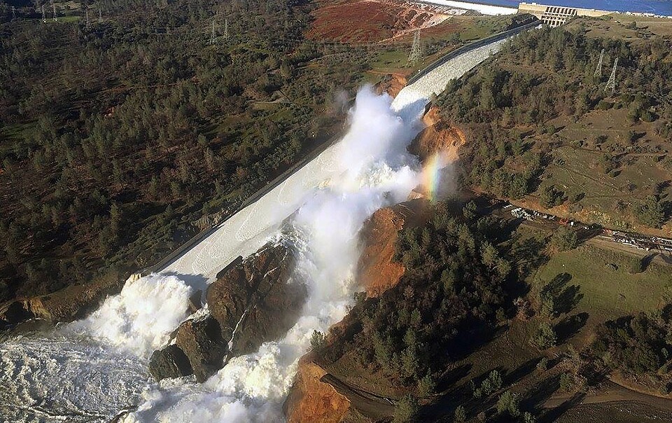 A photo of turbulent water rushing over the damaged spillway of the Oroville Dam in California in 2017.